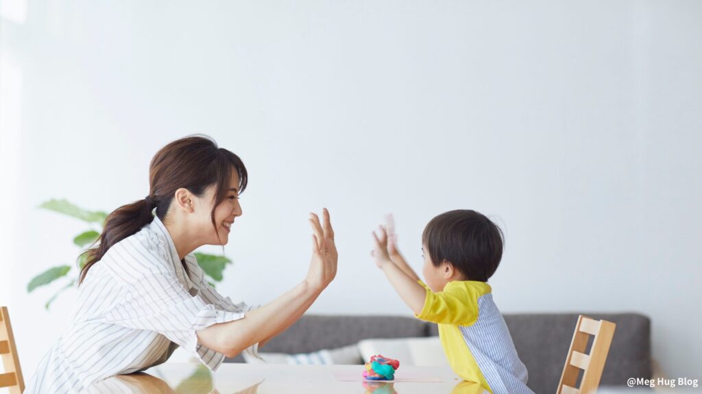 １歳の子どもと母がハイタッチ